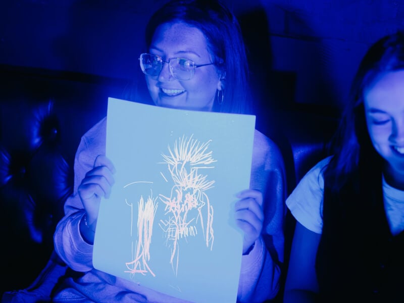 A woman shows off her finished life drawing sketch